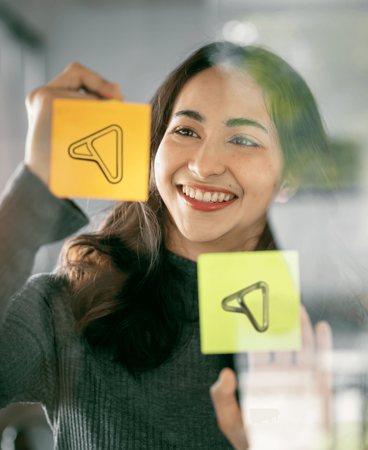 Person holding yellow and green sticky notes with Ingenia logo