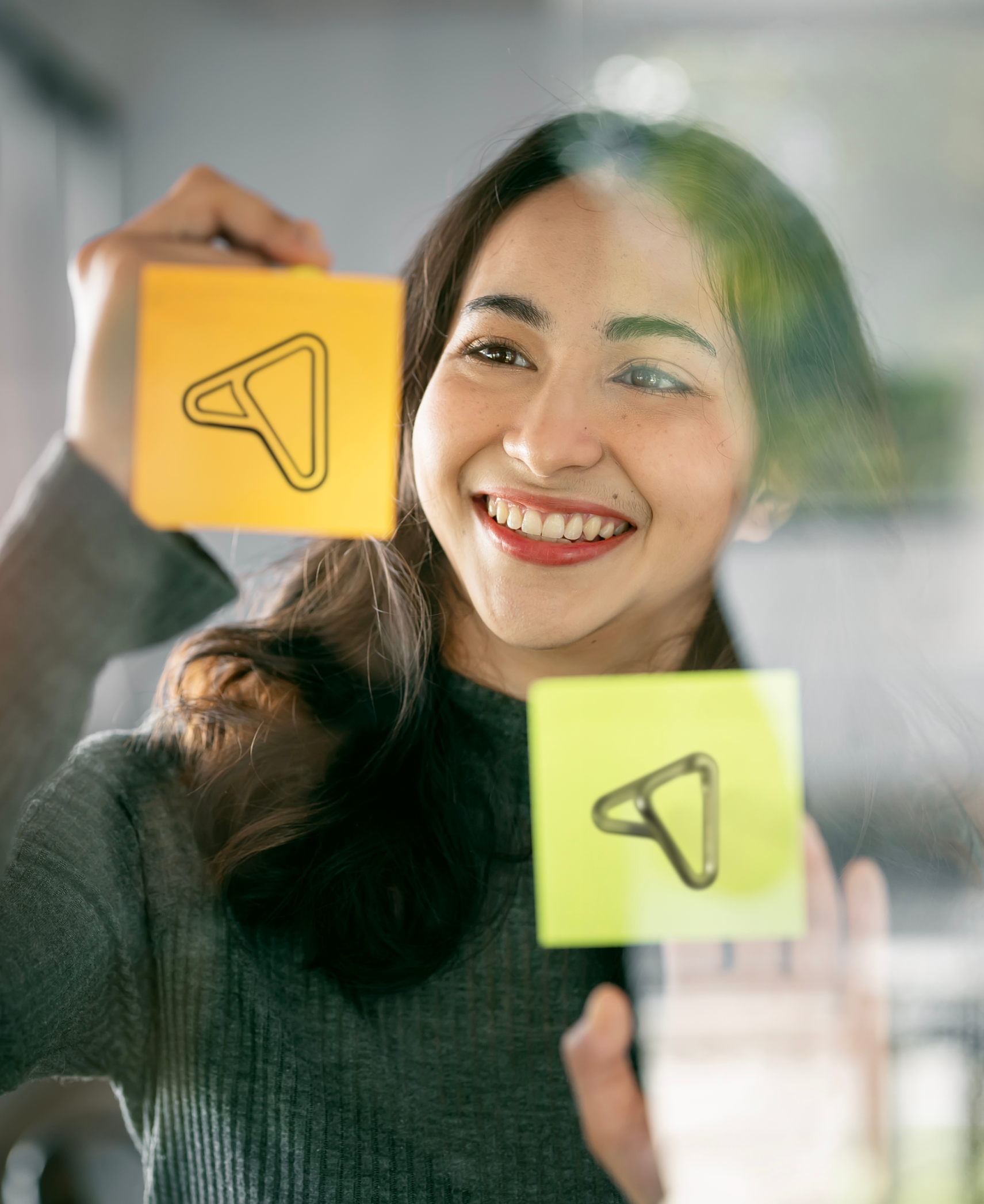 Person holding yellow and green sticky notes with Ingenia logo